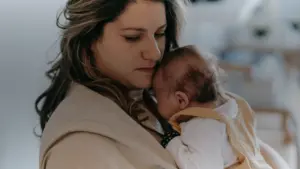 Jeune mère serrant son nouveau-né contre elle