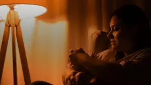 Une mère berce son nouveau-né à la lumière d'une lampe, la nuit