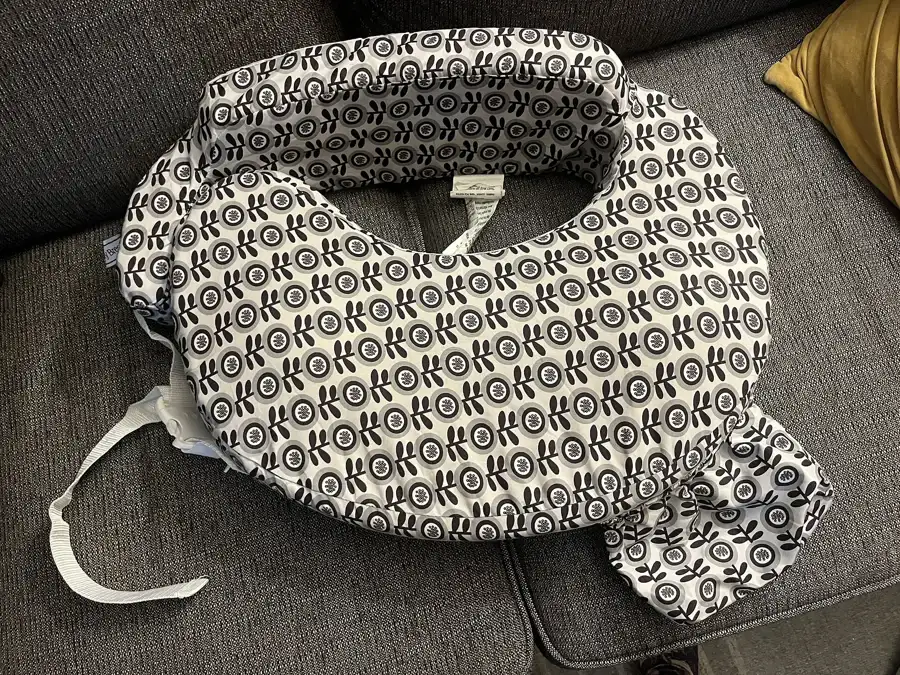 Coussin d'allaitement en forme de croissant posé sur un canapé